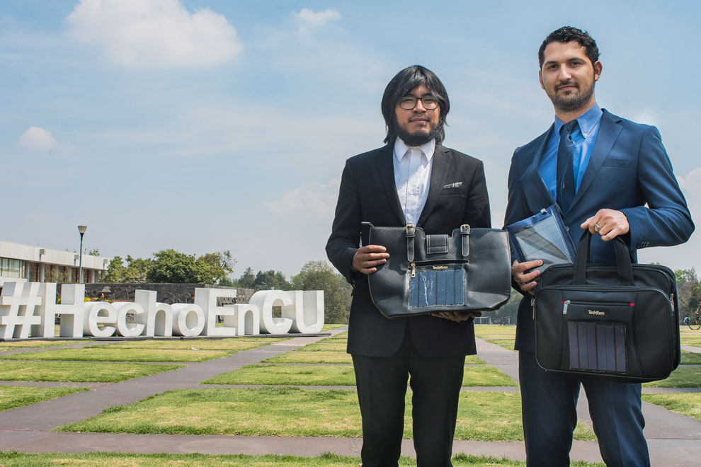 Alejandro Crespo y Miguel Ángel González con las nuevas versiones de sus cargadores solares en bolsas y maletas (Gaceta UNAM)
