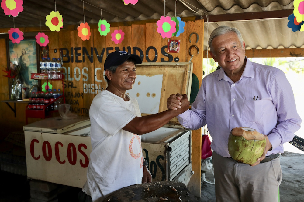 López Obrador toma agua de coco y pide no usar popotes