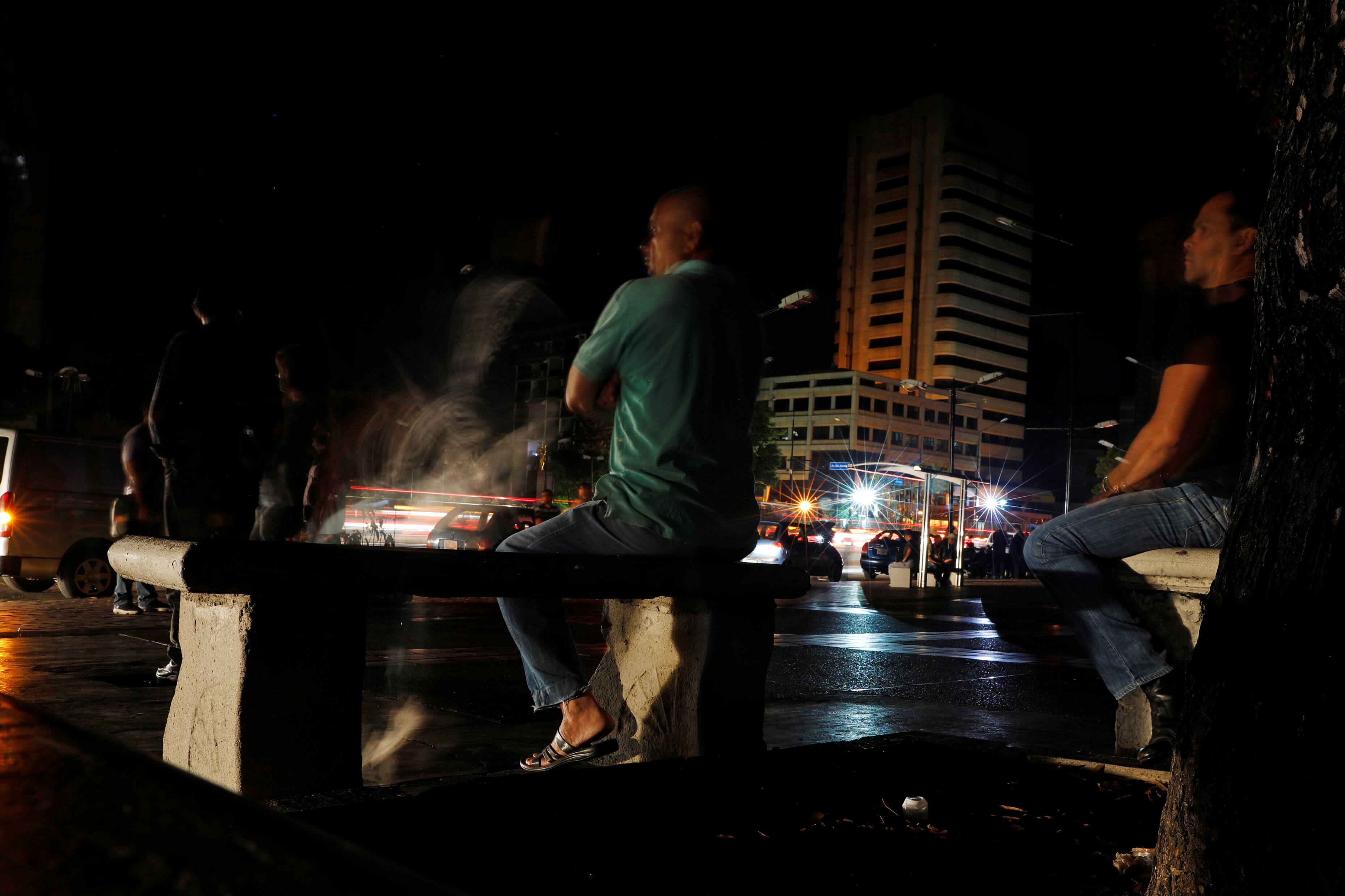 Foto: Un hombre se sienta en un parque mientras los autos pasan durante un apagón en Caracas, Venezuela, el 7 de marzo del 2019