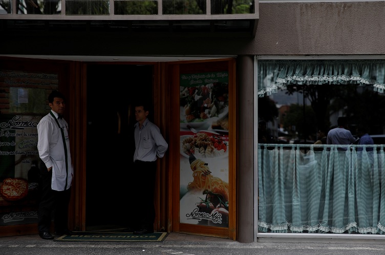 Foto: Trabajadores se paran en la puerta de un restaurante durante un apagón en Caracas, Venezuela, el 7 de marzo de 2019