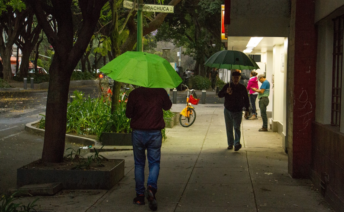 Foto: Dos personas caminan en calles de la Ciudad de México cubriéndose con paraguas por la lluvia, el 4 de marzo del 2019