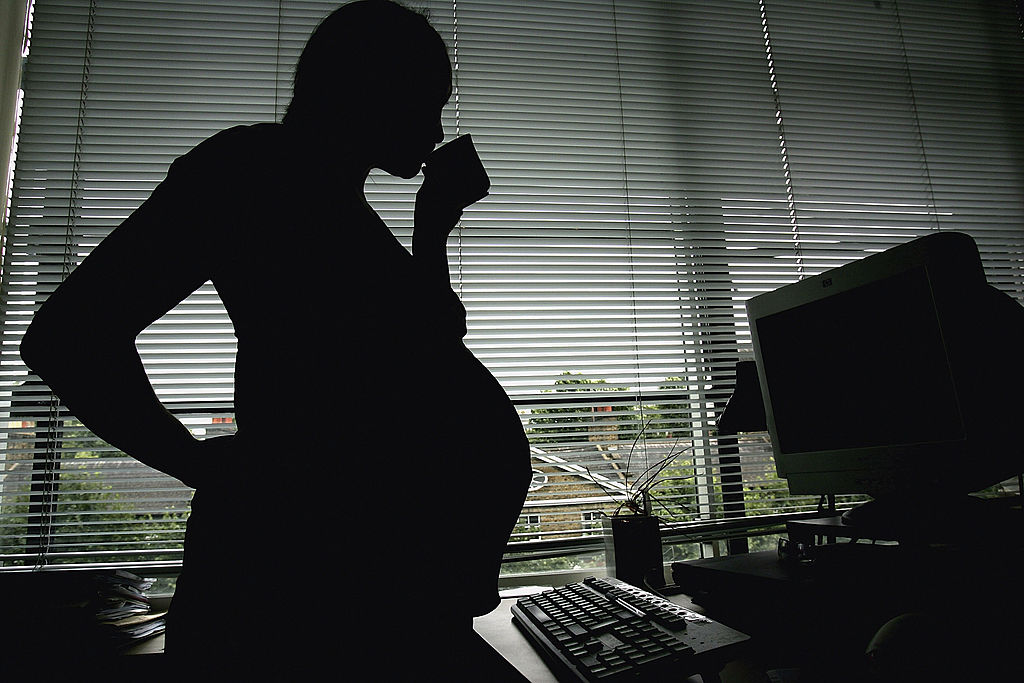 Foto: Una mujer embarazada parada en la estación de trabajo en una oficina. El 18 de julio de 2005