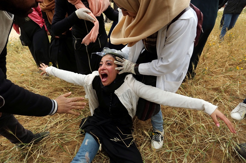 Foto: Mujer palestina reacciona después de inhalar gas lacrimógeno disparado por fuerzas israelíes durante una protesta en la Franja de Gaza, marzo 30 de 2019 (Reuters)