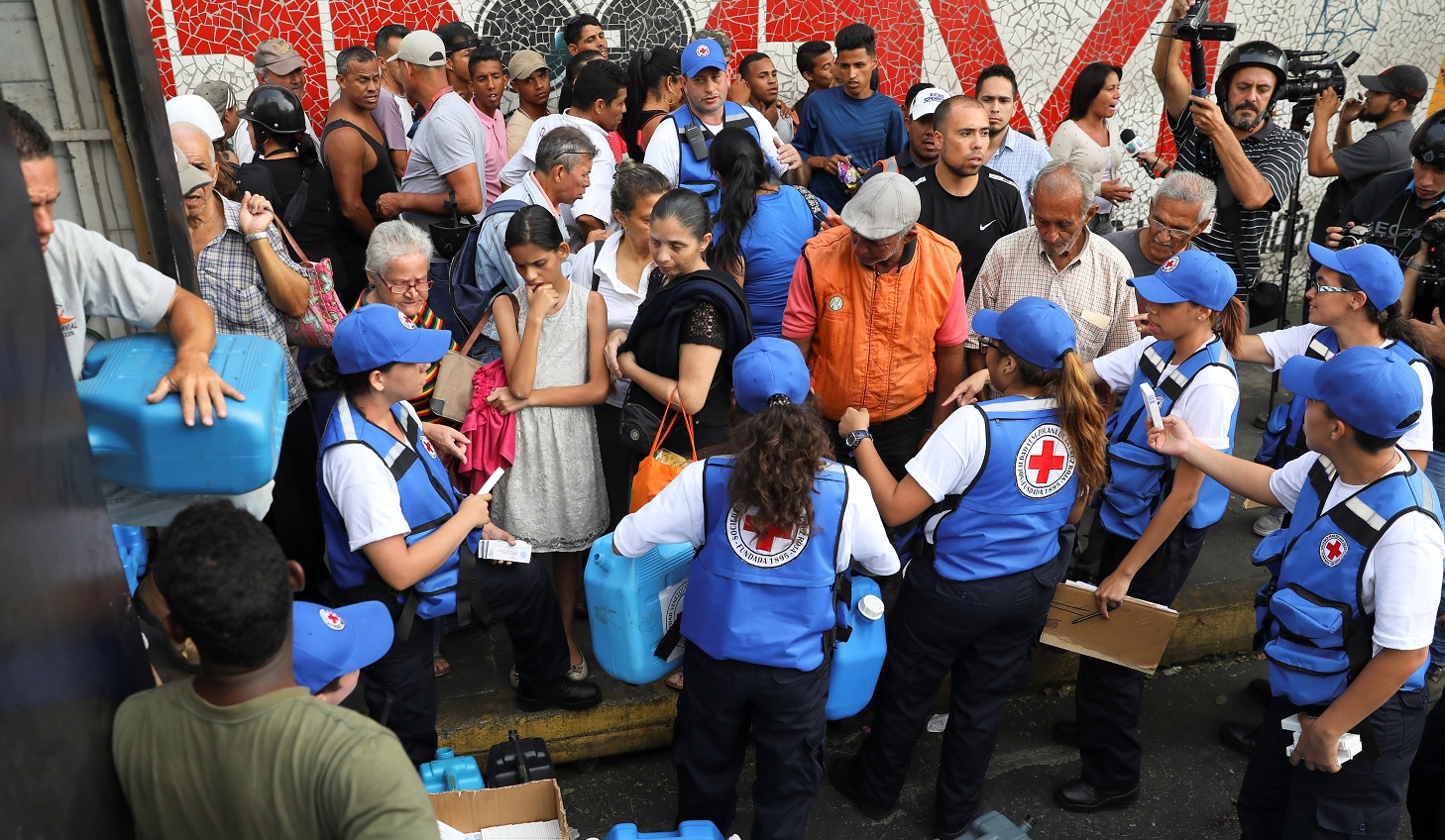 Foto: Trabajadores de Cruz Roja Venezolana reparten agua y píldoras de purificación en el barrio de Agua Salud, en Caracas. El 16 de abril de 2019