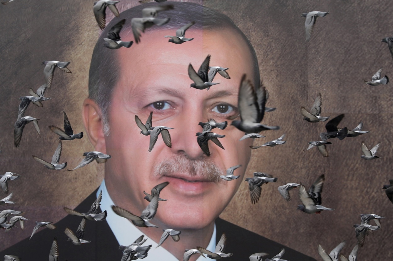Foto: Las palomas vuelan frente a un gran póster del presidente turco Tayyip Erdogan en Bursa, Turquía, 6 de abril de 2019 (Reuters)