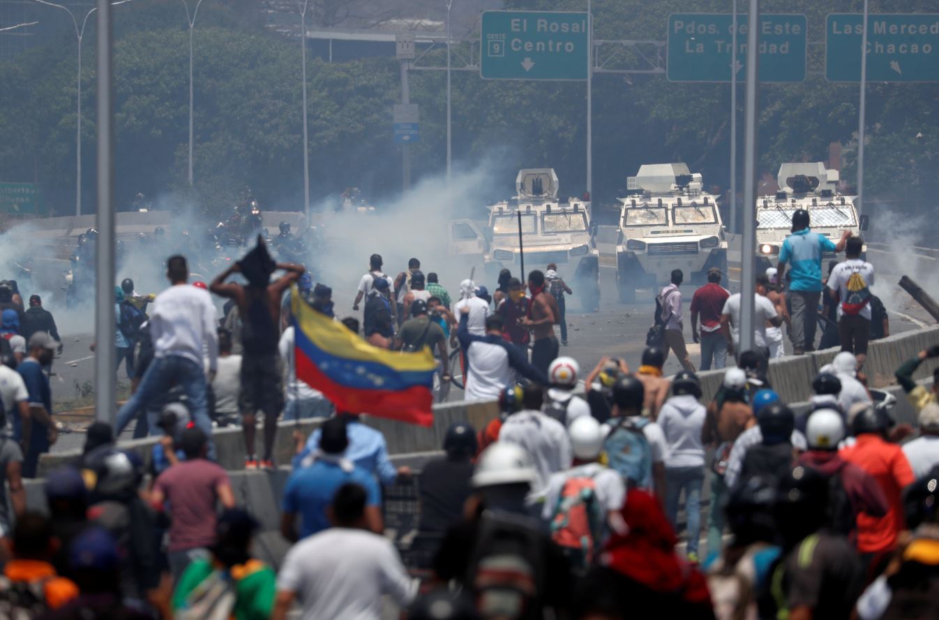 Manifestantes de oposición se enfrentan a tanquetas militares, utilizadas para disuadir las protestas por el régimen de Nicolás Maduro (Reuters)