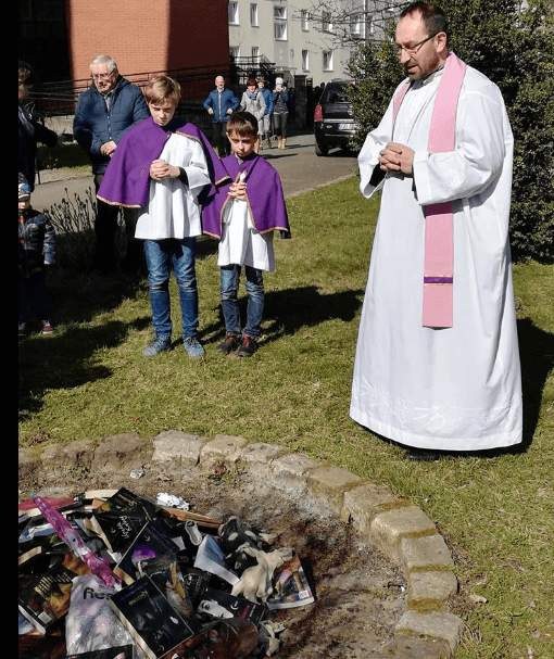Sacerdotes frente a una hoguera, montada en el patio de una instalación de la Iglesia, donde se quemaron los libros y otros objetos (Facebook/smsznieba)