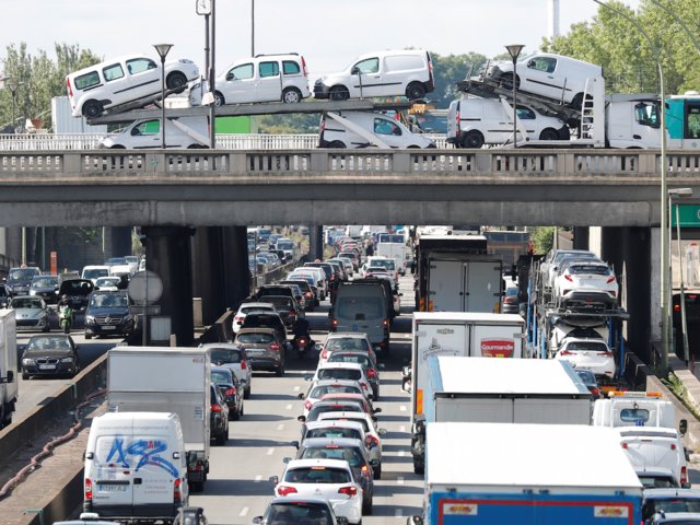 Un camión transporta vehículos sobre uno de los puentes que pasan sobre la autopista periférica de Paris (Reuters)