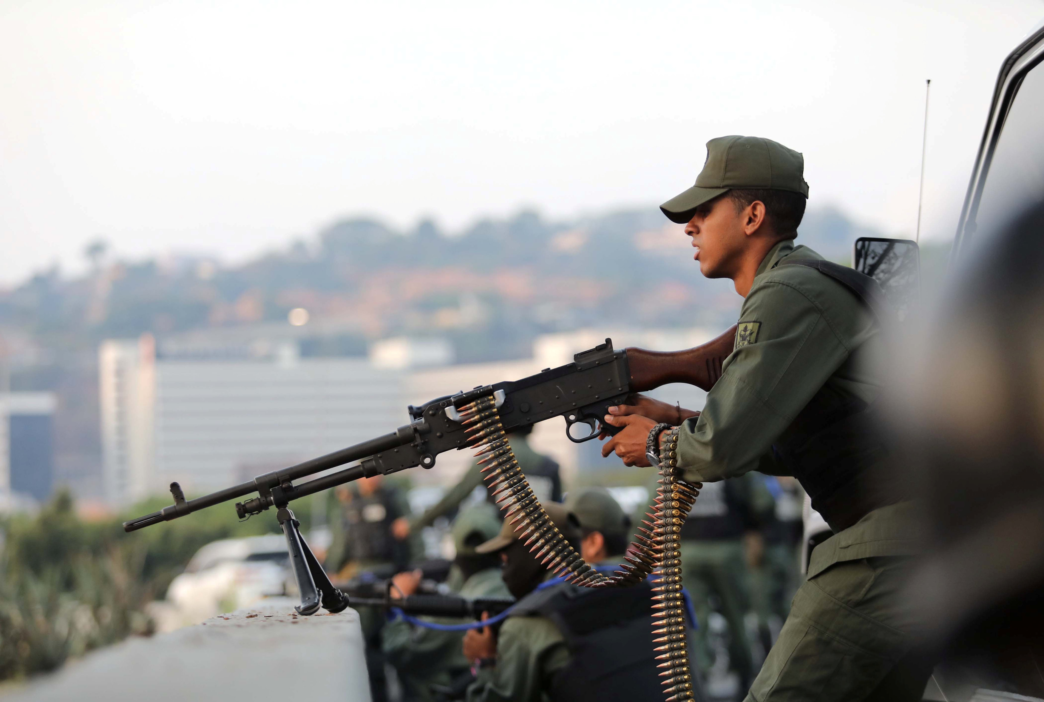 Un militar apunta una ametralladora hacia la base aérea Generalísimo Francisco Miranda 'La Carlota' en Caracas (Reuters)