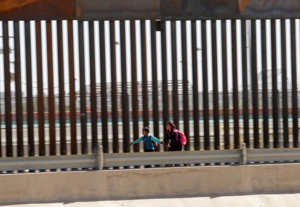 Foto: Dos migrantes corren para solicitar asilo después de cruzar ilegalmente la frontera en El Paso, Texas, EEUU. El 21 de abril de 2019