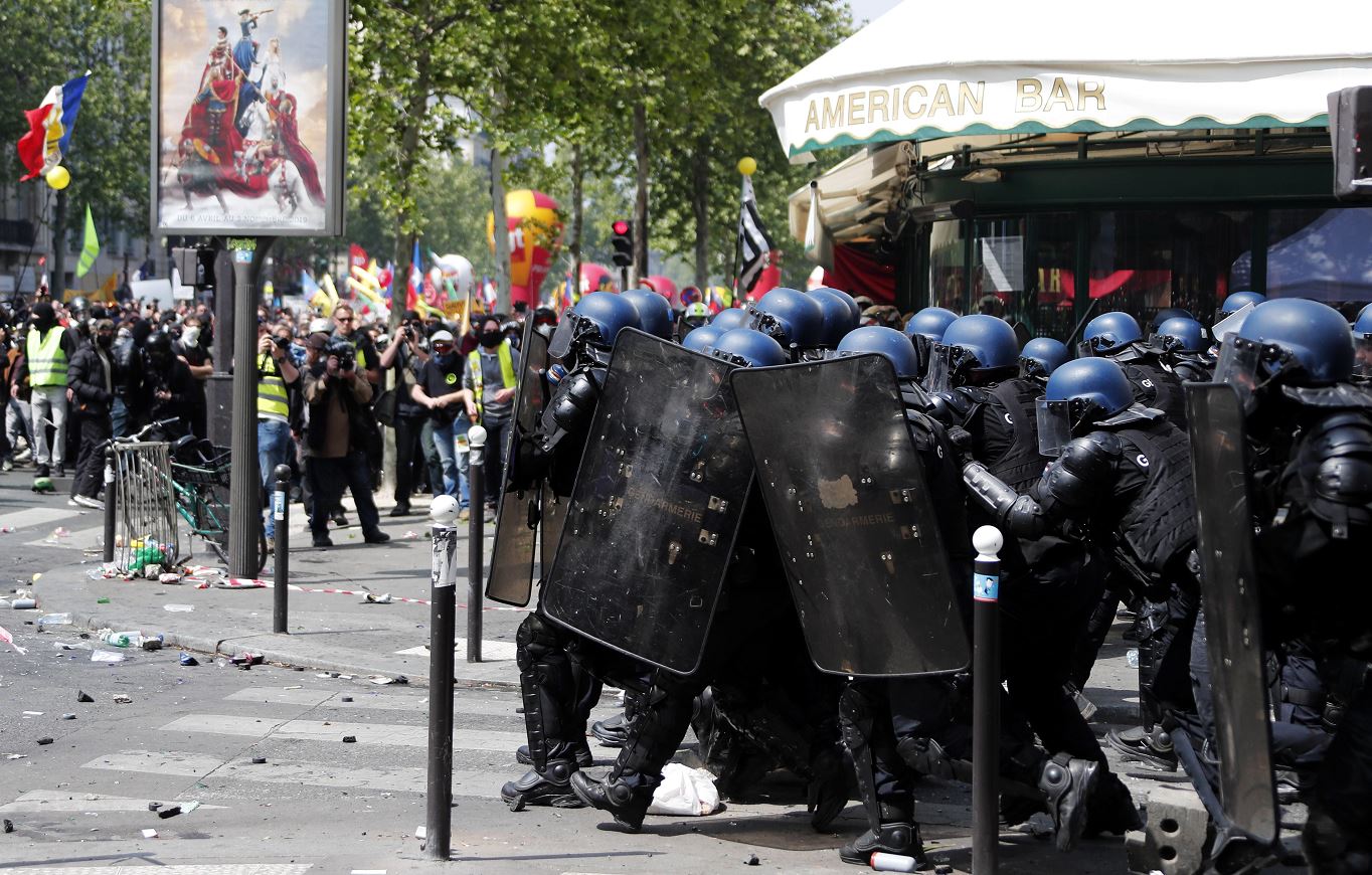 fOTO: La policía antidisturbios se protege del lanzamiento de proyectiles por parte de los manifestantes, 1 mayo 2019