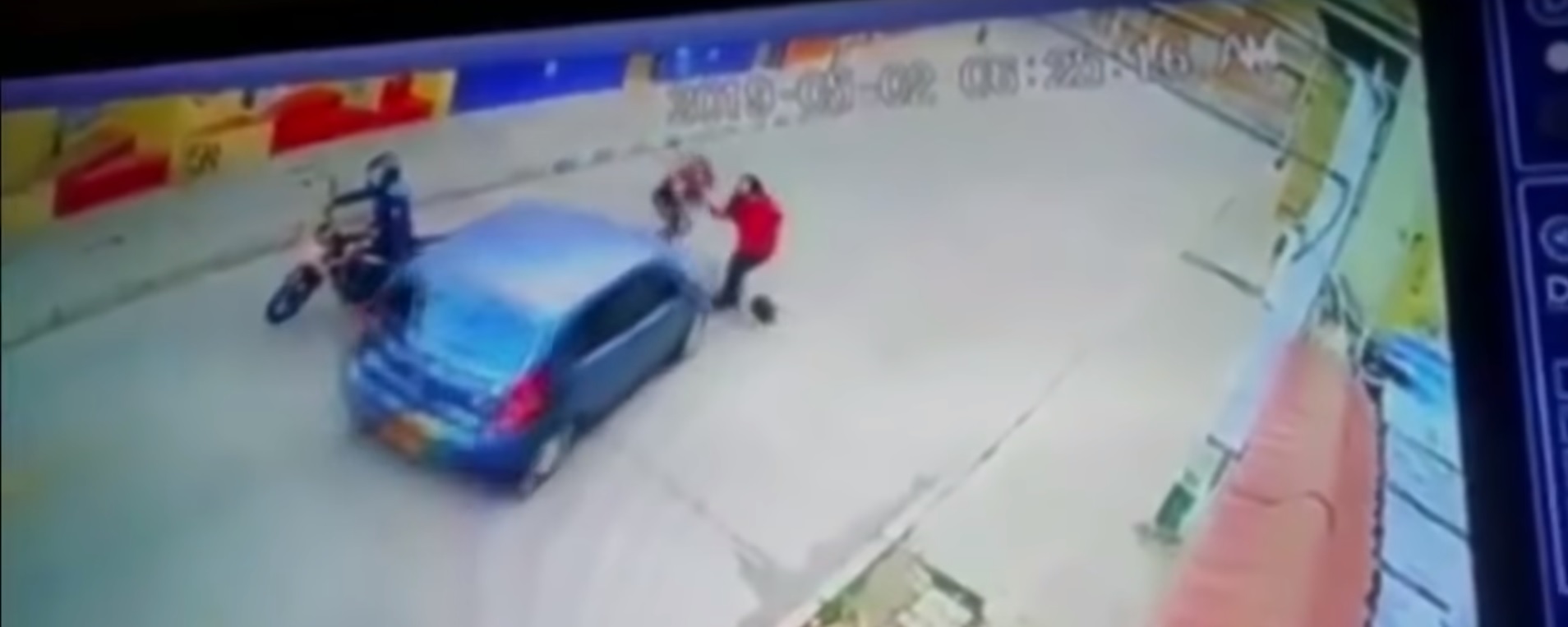 Momento en el que el automovil azul toma la desición de embestir a la ladrona para alejarla de su víctima (Noticias Caracol Captura de Pantalla)