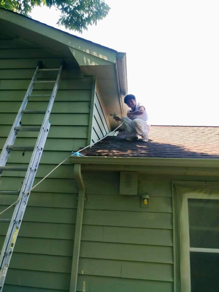 Un miembro del grupo se dedica a limpiar el tejado de la casa de la pareja hacia el final de los trabajos de reparación (Movimiento Migrante Mesoamericano)