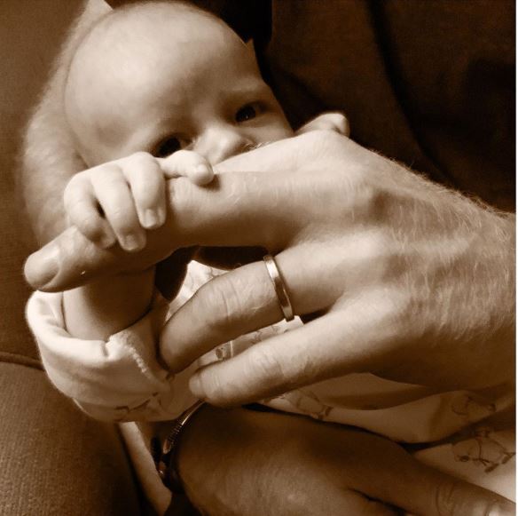 Foto: En la imagen se ve al niño recostado en el regazo del príncipe, al que le agarra el dedo corazón de la mano izquierda, 16 junio 2019