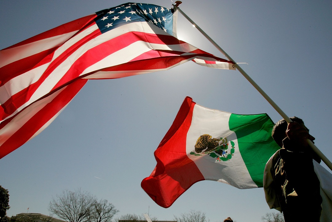 Foto: Un hombre carga una bandera de Estados Unidos y otra de México. El 27 de marzo de 2006