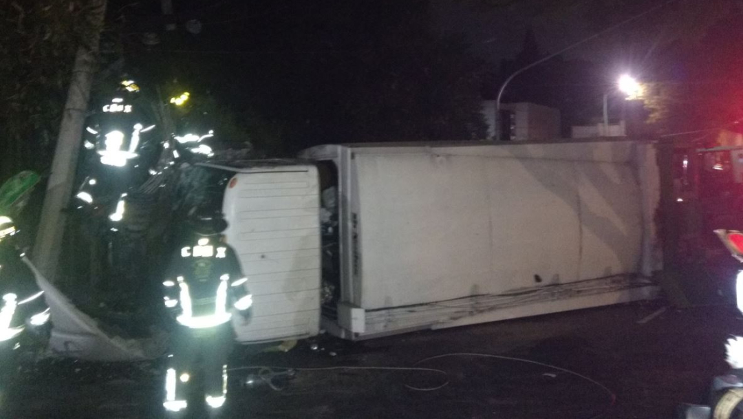 Foto: El conductor de un camión de basura perdió el control del vehículo y volcó sobre un camellón, 27 junio 2019