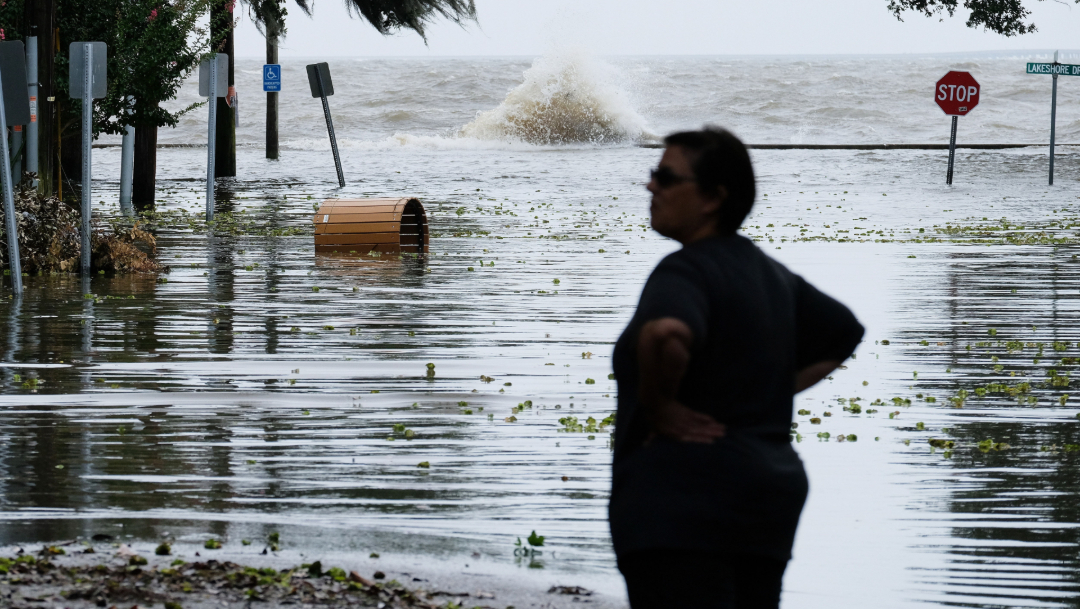 fOTO: Una mujer se para frente a una carretera inundada cerca del lago Una mujer parada frente a una carretera inundada cerca del lago Pontchartrain cuando se aproxima el huracán Barry en Mandeville, Louisiana.