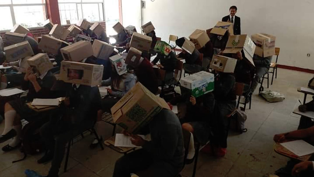 Foto Maestro pone cajas de cartón en la cabeza a alumnos para evitar que copien 29 agosto 2019