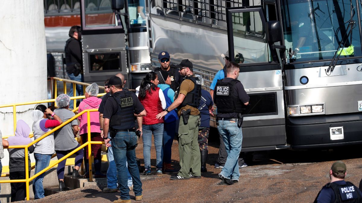 Foto: Agentes de ICE suben a un autobús a varios migrantes que trabajaban en una planta procesadora de alimentos en Mississippi, EEUU. El 7 de agosto de 2019. AP