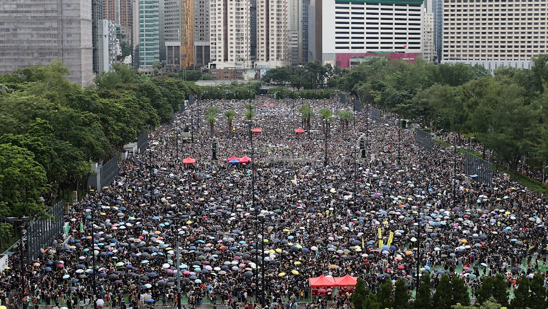 Foto: Una multitud se refugia de la lluvia bajo paraguas durante una nueva marcha contra el gobierno en Hong Kong, 18 agosto 2019