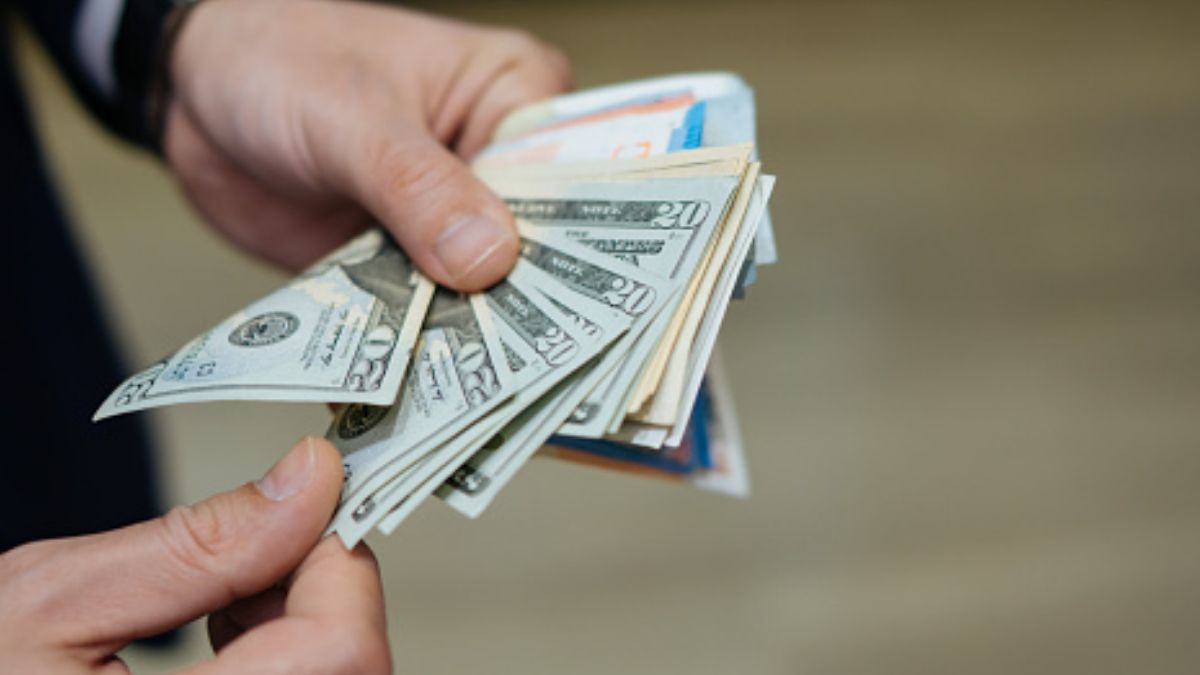 Foto: Un hombre cuenta varios billetes de 20 dólares. Getty Images/Archivo