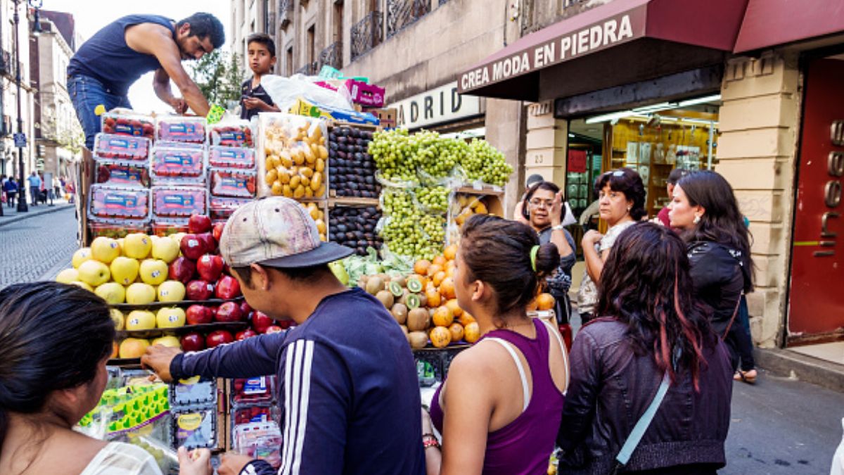 Foto: Varias personas comprar fruta a un vendedor ambulante en la zona Centro de la Ciudad de México. Getty Images