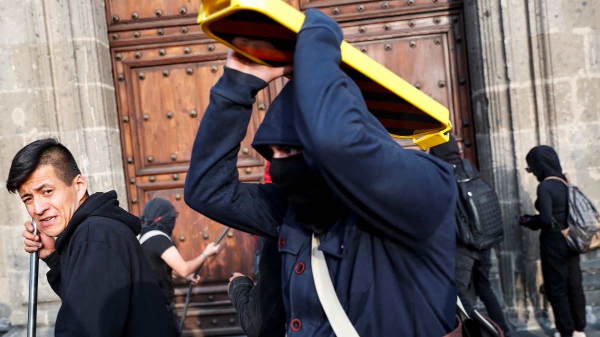 Foto: Encapuchados lanzaron todo tipo de objetos contra la puerta de Palacio Nacional. Reuters