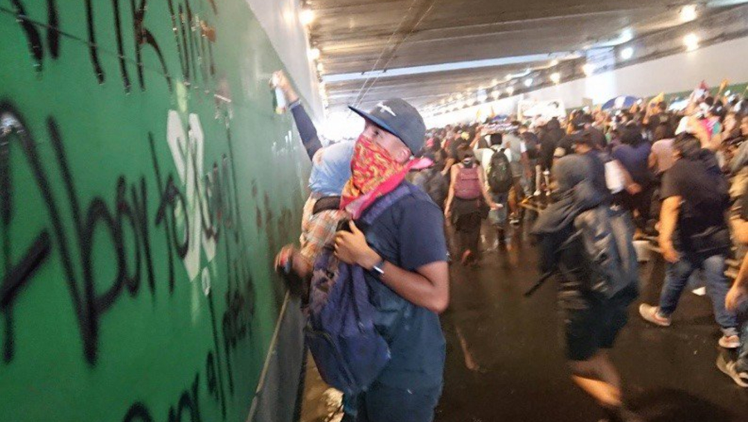 Joven encapuchado realiza pintas en un bajo puente, 02 octubre del 2019 (Twitter @ContraReplicaMX)