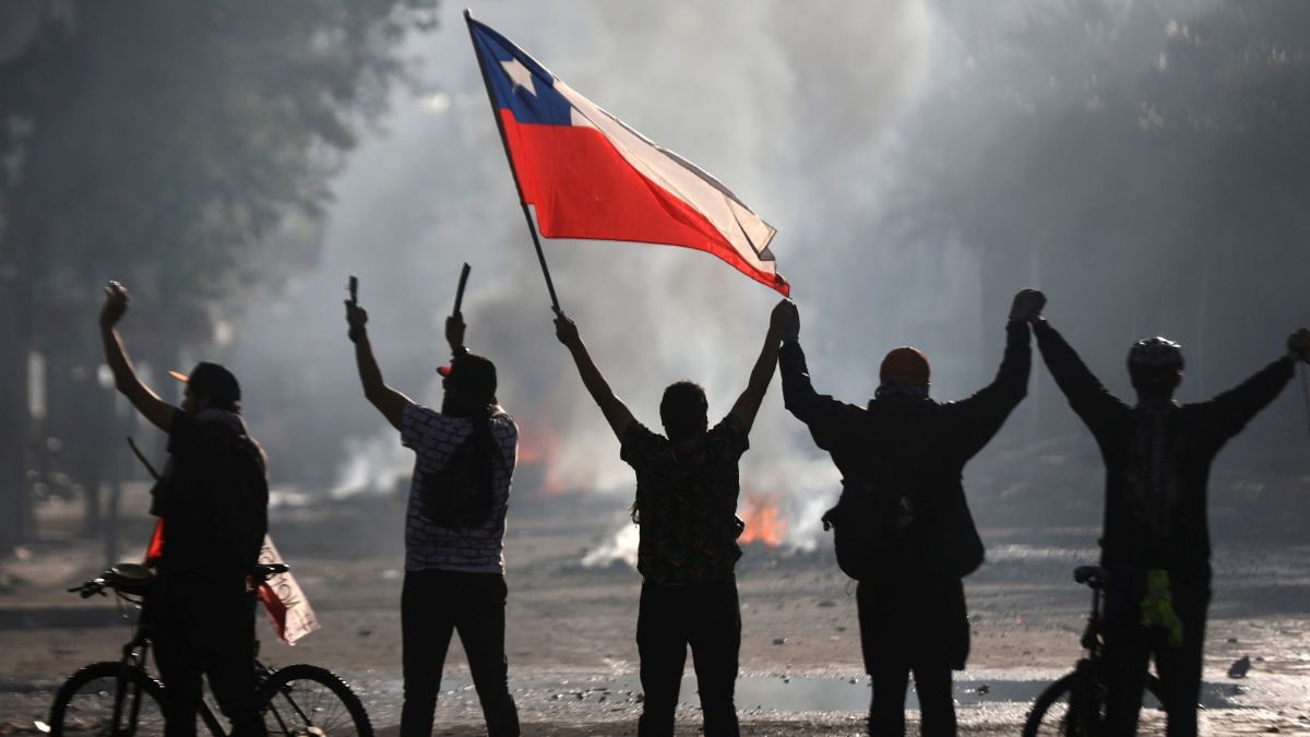 Foto: Manifestantes ondean una bandera de Chile en las calles de Santiago. Reuters