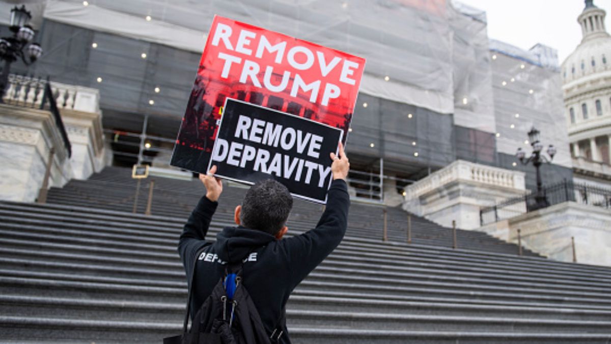Foto: Un joven carga carteles con la leyenda “Remove Trump, Remove Depravity” en la escalinata del Capitolio. Getty Images
