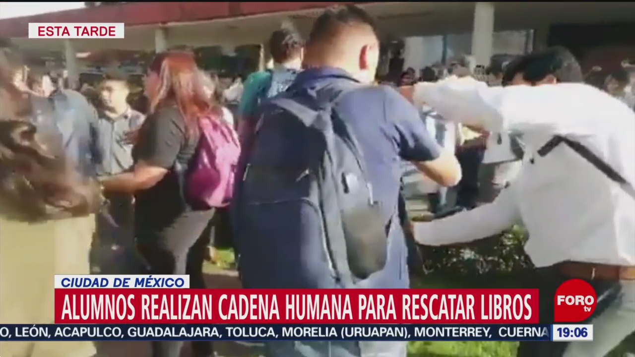 FOTO: Alumnos realizan cadena humana para rescatar libros de vandalismo en la UNAM, 14 noviembre 2019