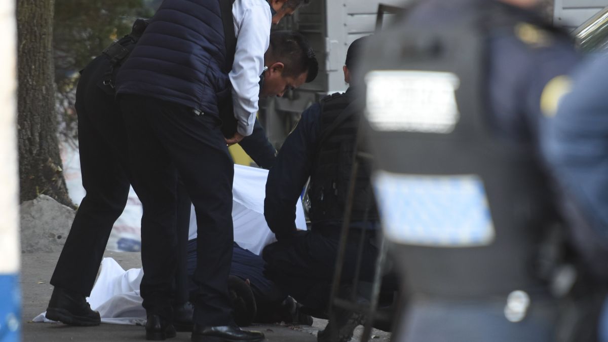 Foto: Policías cubren con una manta blanca el cuerpo de un hombre. Cuartoscuro