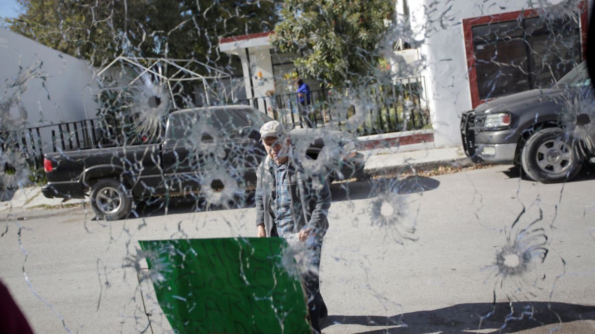 Foto: Un hombre es fotografiado a través de un cristal acribillado a balazos de una tienda en el municipio de Villa Unión, Coahuila. Reuters