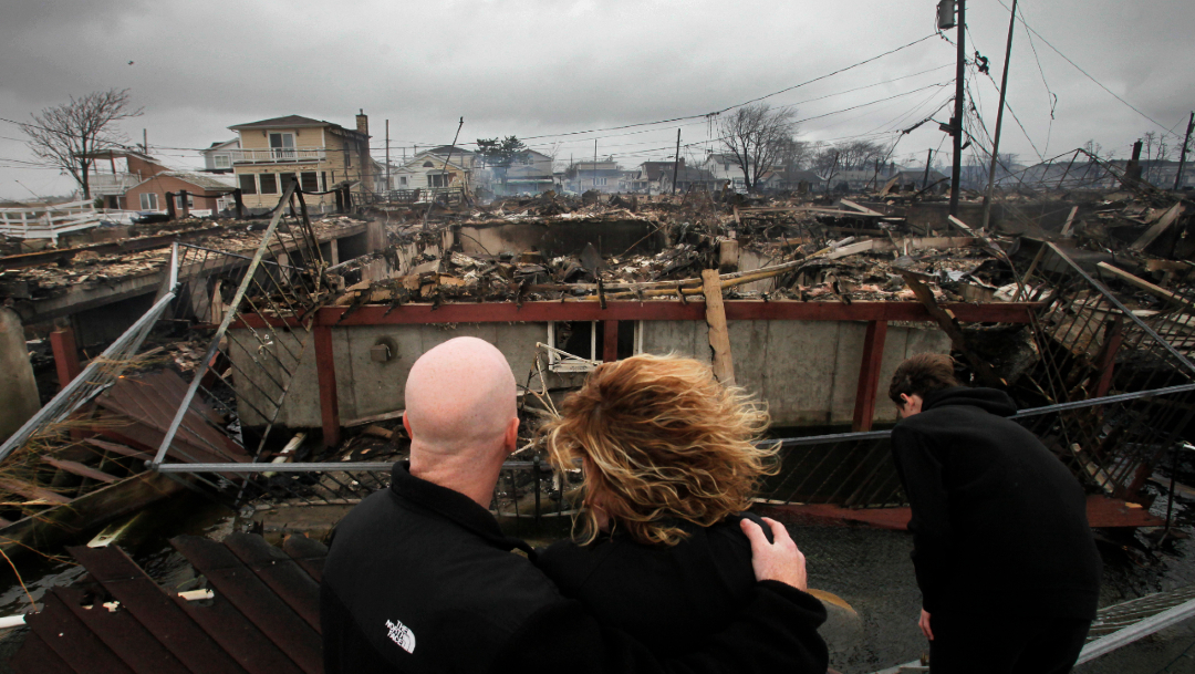 Una familia observa los restos de su casa tras el paso de la tormenta Sandy por Nuev York, Estados Unidos, 6 diciembre 2012
