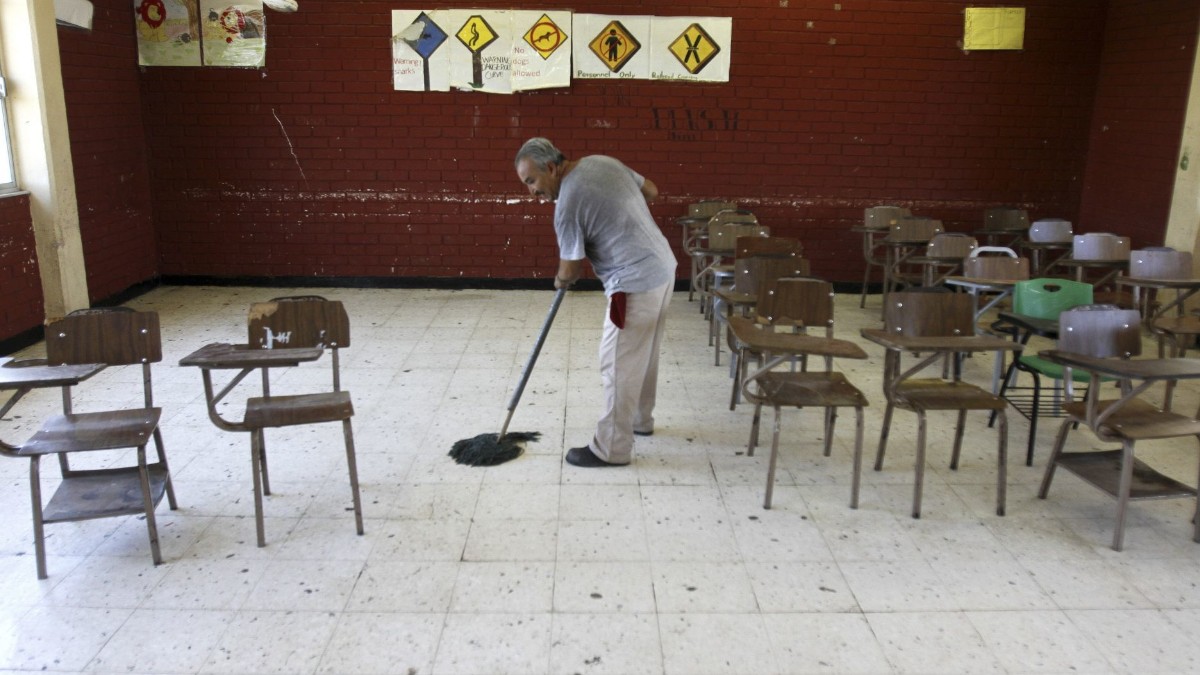 Foto: Un señor limpia un salón de clases. Cuartoscuro