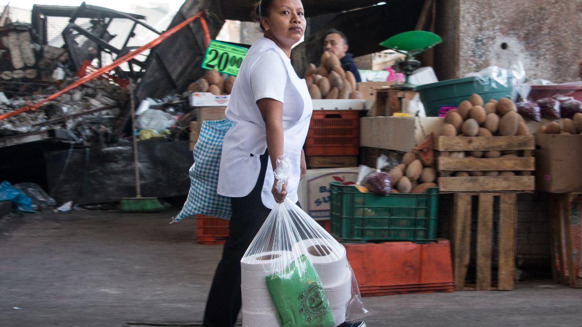 Foto: Una señora carga bolsas de plástico y rollos de papel. Cuartoscuro