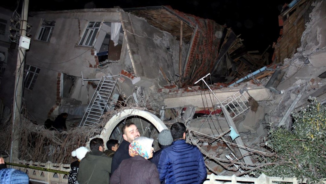 Foto: Un grupo de personas se paran frente a un edificio derrumbado en Elazig, Turquía, el 24 de enero de 2020 (Reuters)