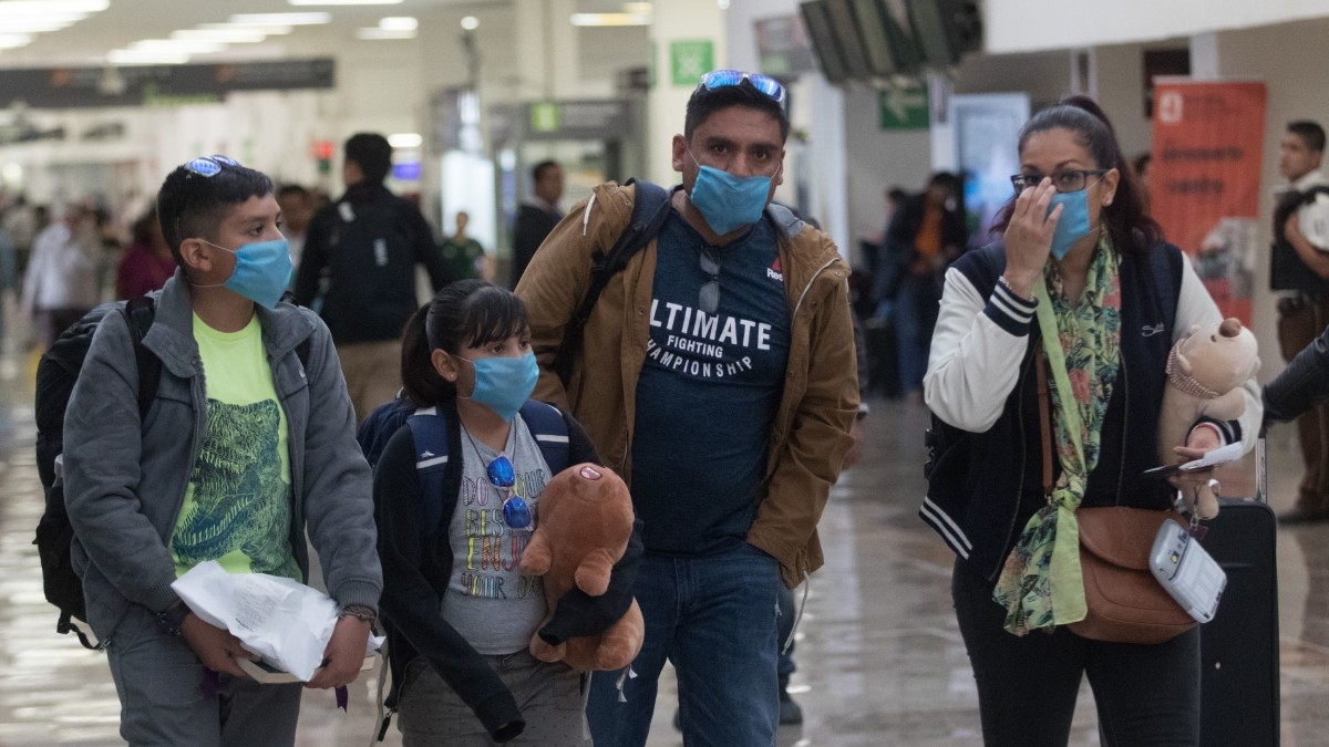 Foto: Una familia usa cubreboca en el Aeropuerto Internacional de la Ciudad de México. Cuartoscuro
