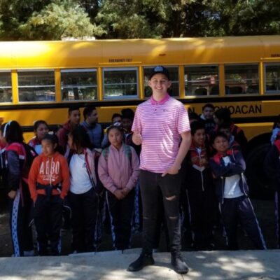 Joven estadounidense compra autobús, lo llena de útiles y lo dona a escuela de Michoacán