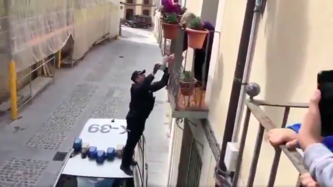 Foto Policía trepa a balcón para entregarle regalo de cumpleaños a anciana en España 30 marzo 2020