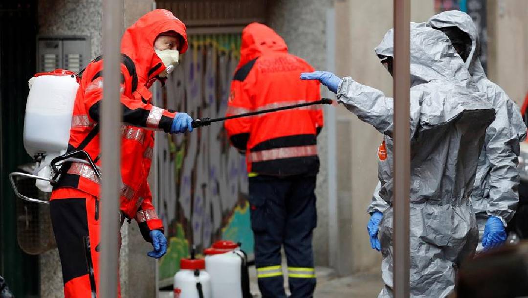 Un grupo de bomberos se desinfecta en España tras satinizar un asilo.(Foto: EFE)