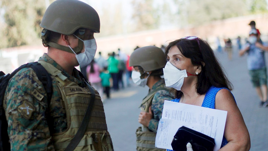 Foto: Una mujer conversa con un militar en Santiago de Chile durante la crisis por COVID-19, 22 marzo 2020
