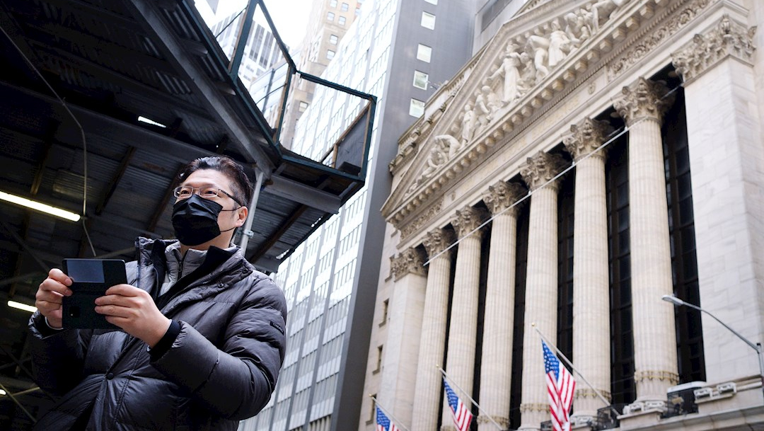 Foto: Un hombre con un tapabocas se para frente al edificio de la Bolsa de Nueva York, 7 marzo 2020