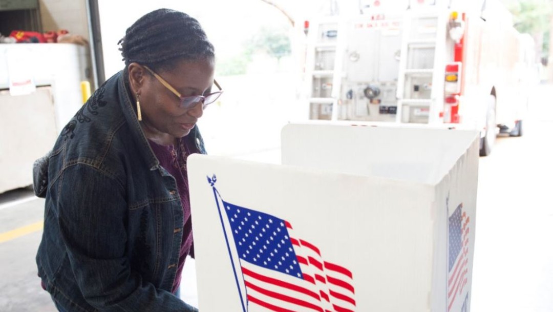 mujer vota en urnas en elecciones en Estados Unidos