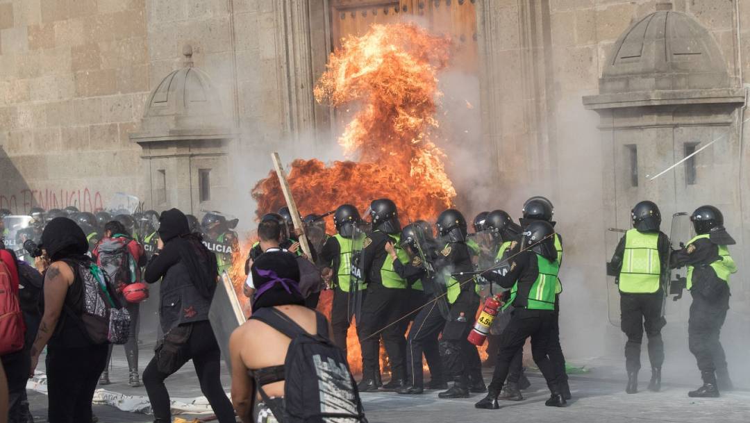 En el Zócalo mujeres encapuchadas tumbaron un tapial que protegía un escenario, pintaron paredes de Palacio Nacional y explotaron cohetones que provocó varias heridas. (Foto: Cuartoscuro)