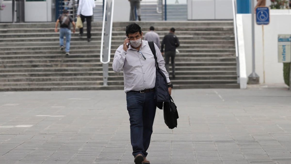 Foto: Un hombre camina por calles de Puebla usando cubre boca. Cuartoscuro