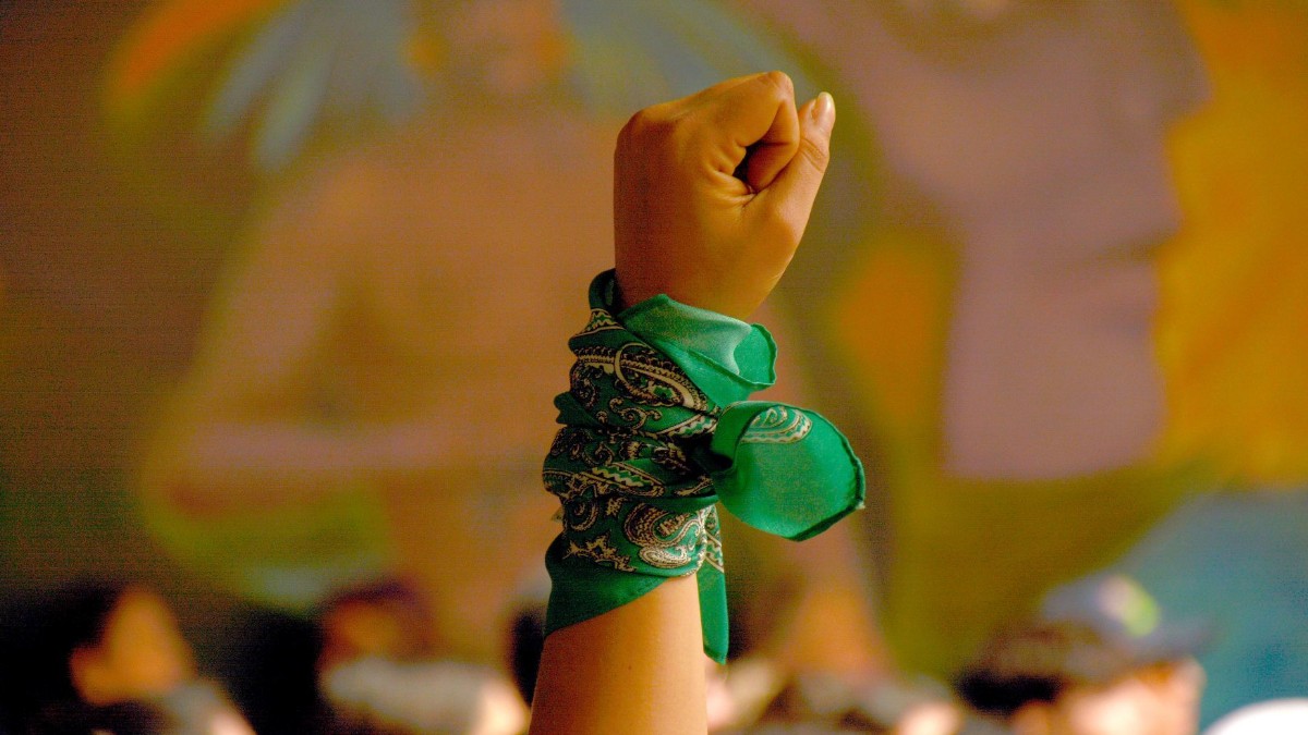 Foto: Una mujer alza el puño con una pañoleta verde. Cuartoscuro
