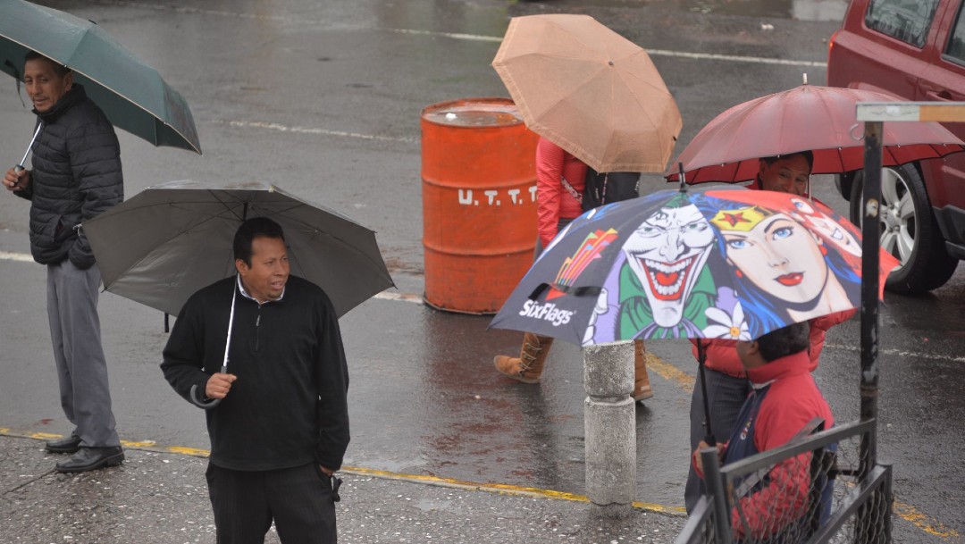 Foto: Un grupo de personas se protege de la lluvia, 15 marzo 2020