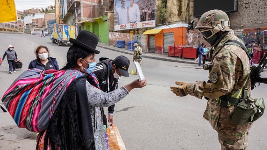Foto: Mujeres y militares usan cubrebocas en calles de Bolivia. Getty Images