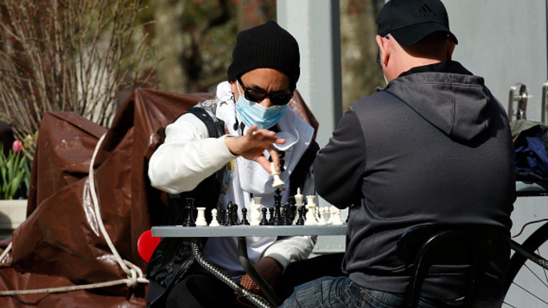 Foto: Dos personas con cubrebocas juegan ajedrez en calles de Nueva York. Getty Images